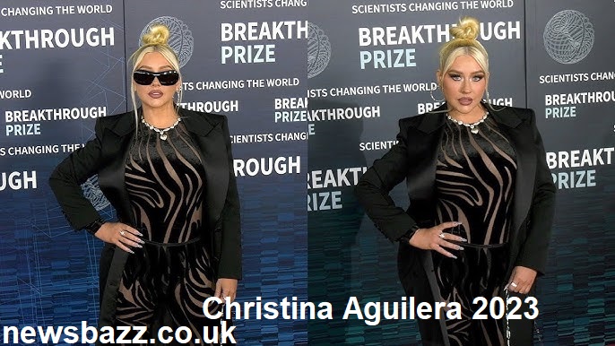 Christina Aguilera performing live in 2023 wearing a sparkling silver outfit.